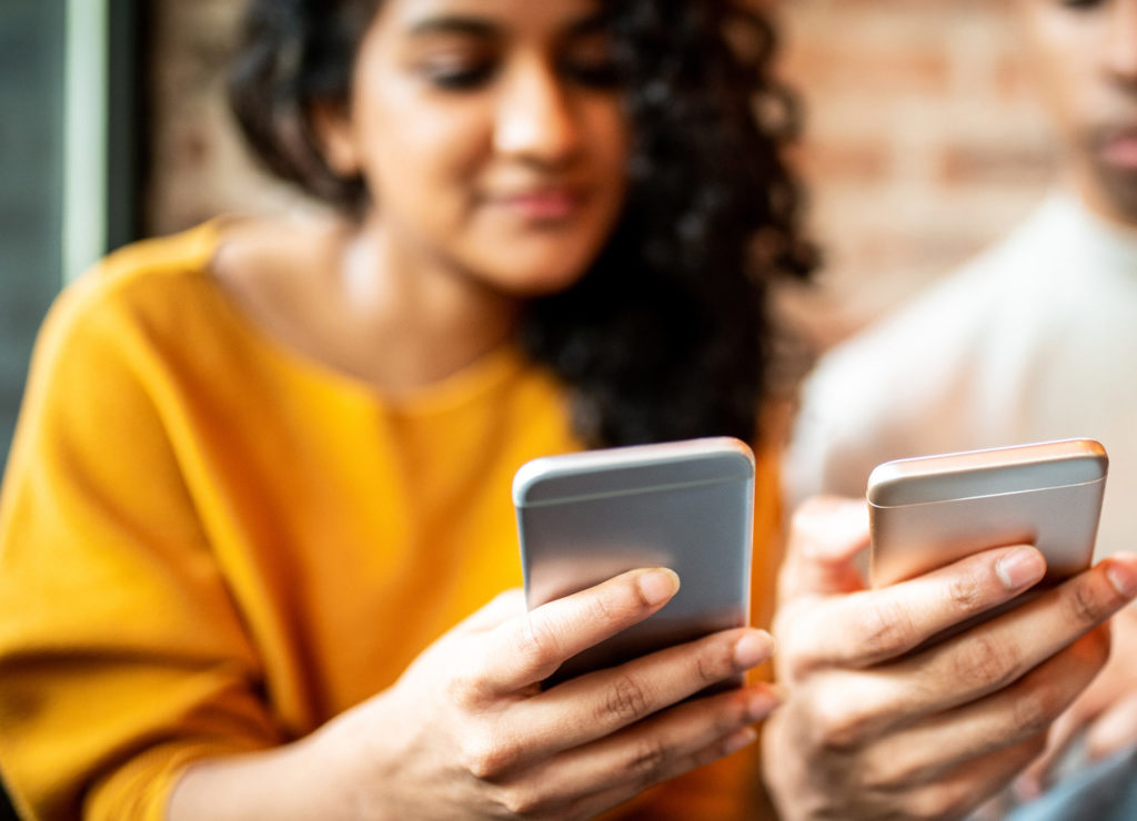 blurry close up of two friends sending money through digital wallet