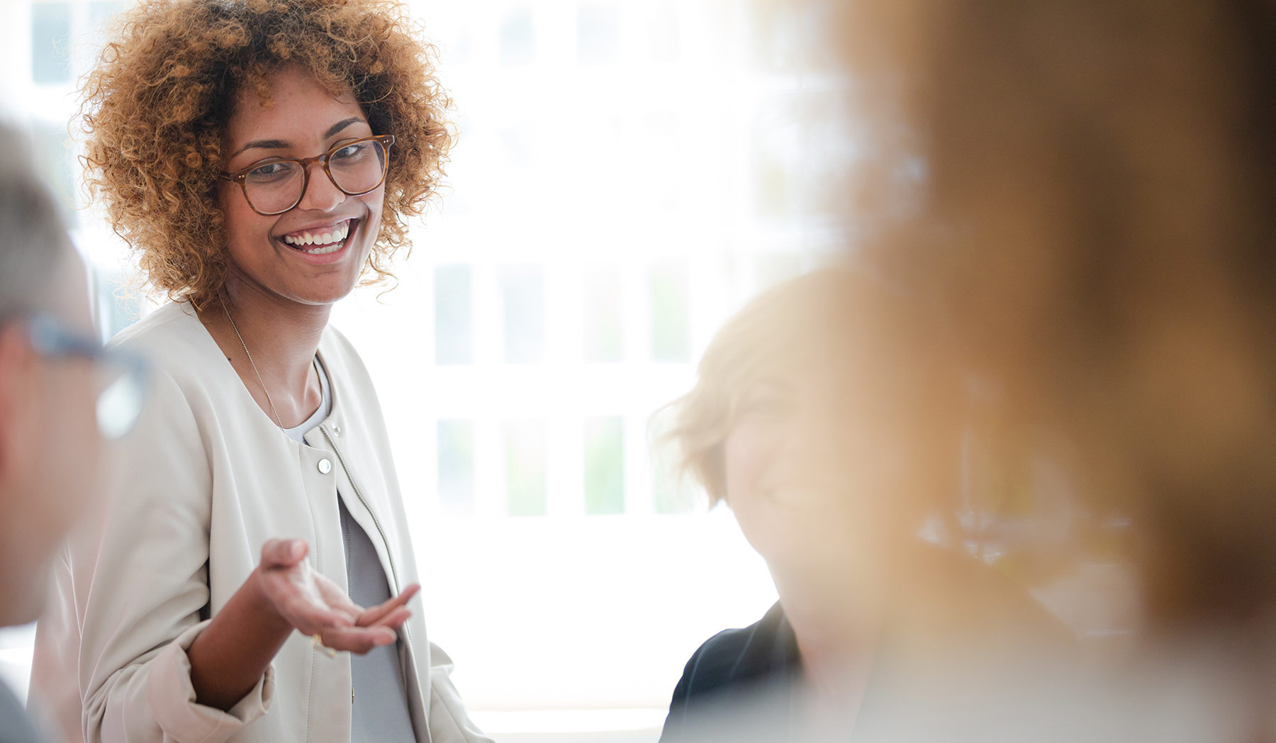 Office workers talking and smiling at meeting