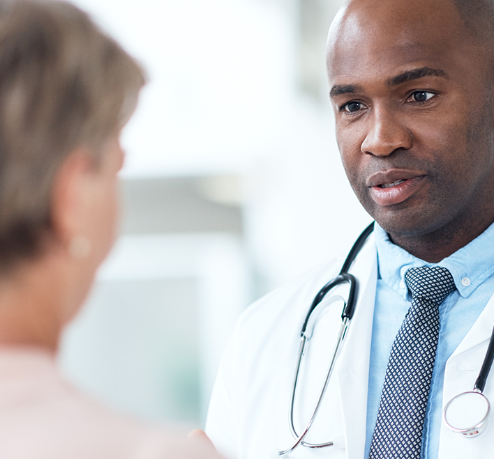 Doctor advising patient, explaining using his hands, while standing